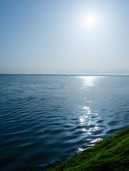 Obraz premium A serene lake reflects the sun creating a beautiful shimmering effect on the water surface and sky 90