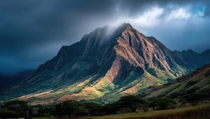 Dramatic mountain peak bathed in golden light, dramatic clouds