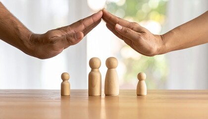 Hands shielding wooden family figurines on wood—evoking protection, care, and emotional security.