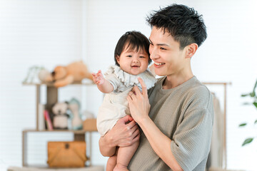 Father, dad, holding baby, daughter in the living room of his home