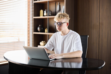 Young person working on a laptop in a modern home office