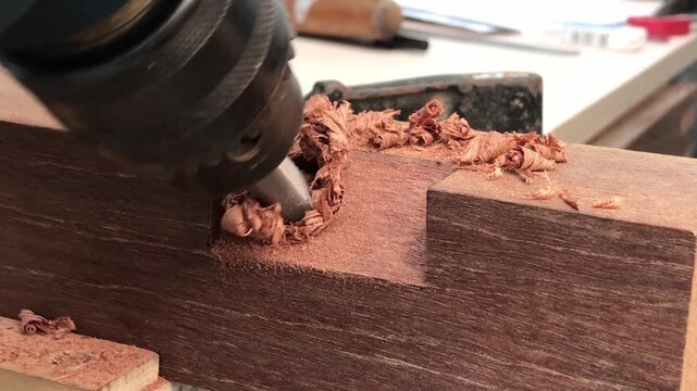 Cutting and shaping wood with a rotating drill bit
