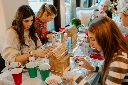 Young women decorating gingerbread houses