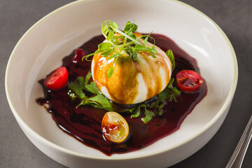 Creamy burrata cheese with beet sauce, arugula and cherry tomatoes