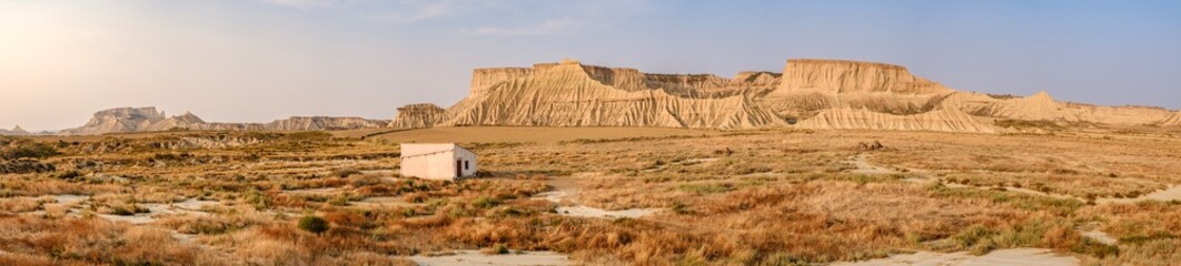 Solitary Rural Building in Bardenas Reales Desert Landscape Navarra Spain. Badlands mesa formations, isolated cabin, golden hour light, Semi-arid