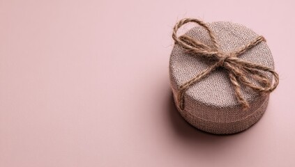A light beige gift box on a pale pink background