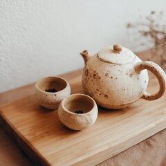 Ceramic teapot and cups on wooden board