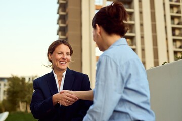 Professional Women Shaking Hands Outside Office Building During Business Meeting, Networking, And Collaboration
