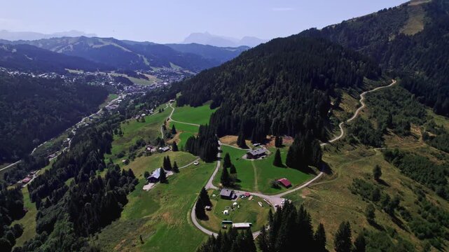 Lush green French Alps tourist destination winter sports slopes with rocky mountain top of Mont Chery and Mount Blanc Massive behind