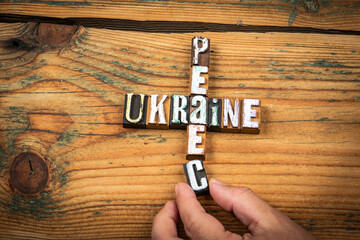 Ukraine and Peace Concept. Wooden letter blocks arranged in a crossword style on a rustic wooden...