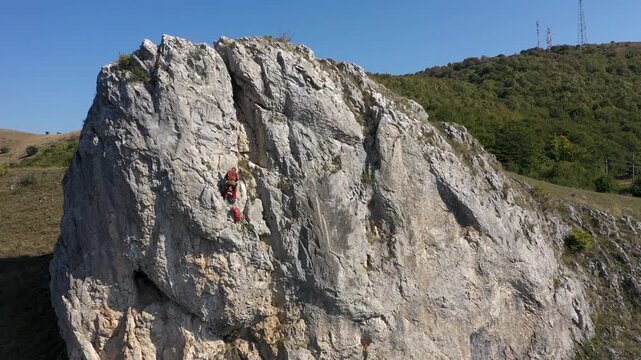  Flying near a mountain rescuer rappelling on a rocky wall with a drone