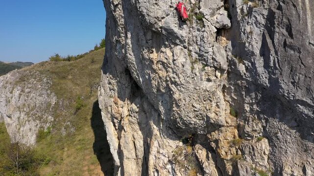  Flying near a mountain rescuer rappelling on a rocky wall with a drone