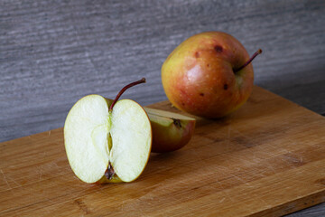 an apple cut in half lies on a board