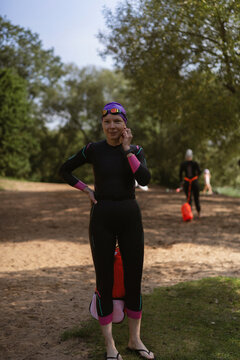 Smiling woman in a wetsuit preparing for water sports outdoor
