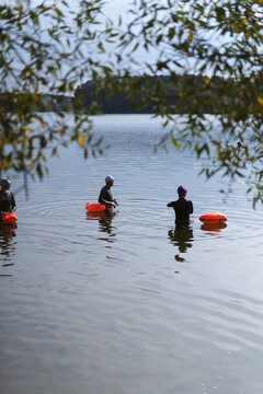 Two women prepare for an open water swim in a lake