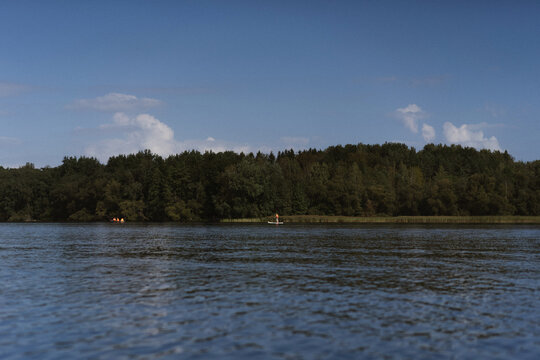 Man paddling on paddleboard on calm lake