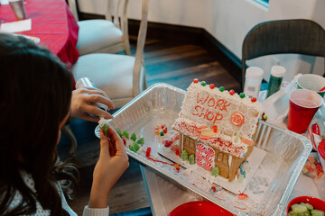 Decorating festive gingerbread workshop house