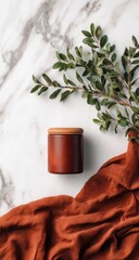 Wooden canister on marble with rust-colored fabric and greenery