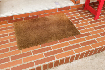 Welcome mat on red brick floor,Overhead of blank doormat at the front door,office or home,space for text.