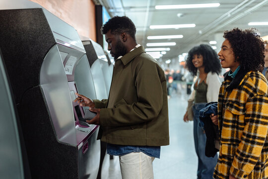 People using ticket machine in subway station