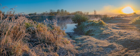 The first frost and fog by the river at dawn