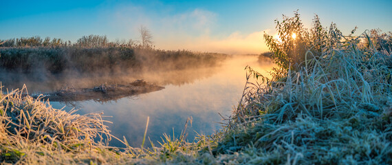 The first frost and fog by the river at dawn