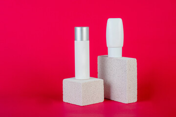 Cosmetic product in tube, bottle, lotion or serum with stylish props on red background. 