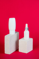 Cosmetic product in tube, bottle, lotion or serum with stylish props on red background. 