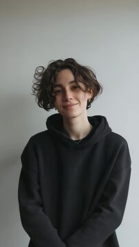 Young caucasian male with curly hair in casual dark hoodie