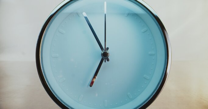 Close Up of Minimalist Round Wall Clock on Warm Background with Moving Clock Hands Showing Precise Time. Contemporary Design Element of Interior. Concept of Time Management, Punctuality. Time Lapse.