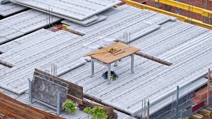 Naklejka premium Multistory Building Construction Site with Precast Reinforced Concrete Ceiling Slabs and Metal Rebar Rods