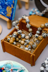 A set of bracelets made of natural stones in an open wooden box at a fair.