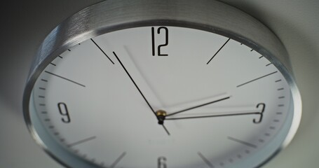 Close Up Shot of Minimalist Wall Clock Hanging on the Wall. Running Hour, Second and Minute Hands on the Dial. Contemporary Design Element of Interior. Concept of Time, Punctuality, Time Management.