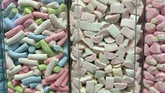 A vibrant display of gummy candies, marshmallows, and sweets at Mercat de la Boqueria, the famous market in Barcelona. The colorful assortment of treats attracts tourists and locals.