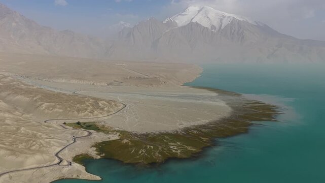 Aerial view of Baisha Lake displaying the stark contrast between the turquoise water and the arid landscape, Baisha Lake, Xinjiang, China.