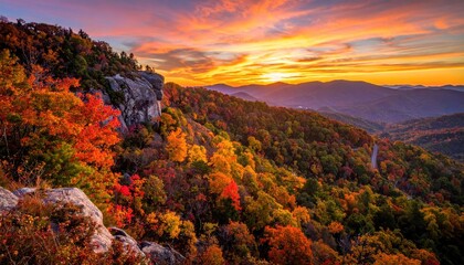 Autumnal mountain vista at sunrise.  Vibrant fall foliage, rocky peaks, and a stunning sunrise over rolling hills