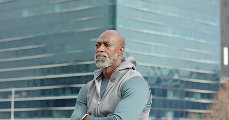 Senior African American man shifting gaze to lens by glass tower deciding next move with smartwatch - Powered by Adobe