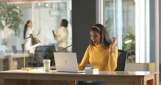 Asian Indian woman reading message on laptop at office desk, reacting with gasp copy space