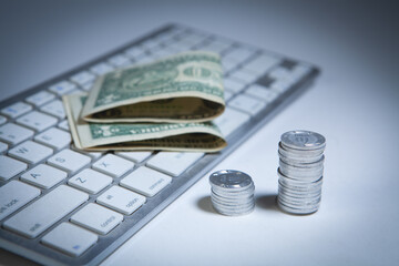Money and coins on the keyboard. Business concept. Selective focus.