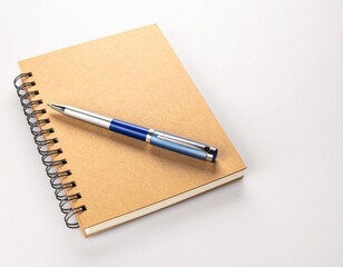Naklejka premium Notebook with brown cover and a blue pen on a white surface.