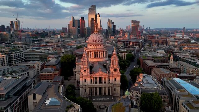 Establishing aerial view of the London skyline with St. Pauls Cathedral and the City skyscrapers  in the background during golden sunset time