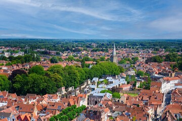 Fototapeta premium Discover the charm of Brugge, Belgium, with this aerial view of its medieval cityscape. Experience iconic architecture, canals, and lush greenery in this picturesque location.