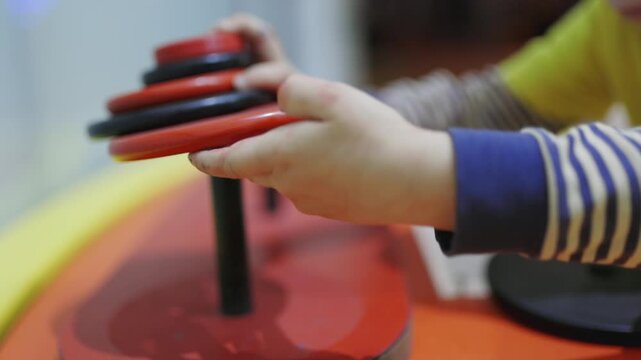 Toddler hands playing with a stacking ring toy