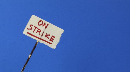 Strike written on a protest sign with a blue background.