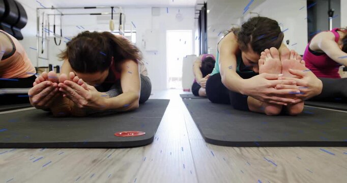 Group of women raising arms in Pilates class, hinging stretching hamstrings with animated circles