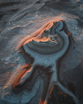 Aerial view of the captivating Tiramisu Rocks, where the sun kisses the striated layers of earth, painting them in hues of gold and umber, Tiramisu Rocks, Mangystau Region, Kazakhstan.