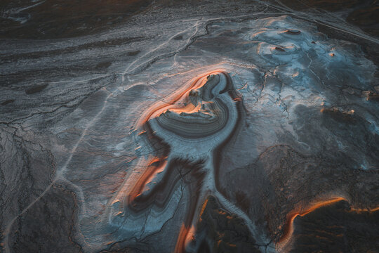 Aerial view of undulating earth revealing striking contrasts of light and shadow across the Tiramisu Rocks, Tiramisu Rocks, Mangystau Region, Kazakhstan.