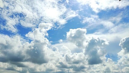 "Dreamy Sky Landscape with Radiant Sunlight and Fluffy White Clouds"