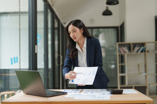 Asian businesswoman showing charts on a video call in office - Powered by Adobe