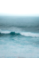 Fototapeta premium Aerial view of ocean waves, boats and sunset